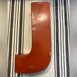 Red metal letter “J” 11” x 5 1/2” x 2 1/2”